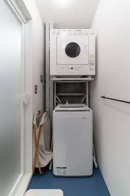 a small kitchen with a microwave and a refrigerator at Rakuna Inn \u904a Kinshicho in Tokyo