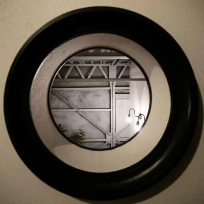 a round mirror on a wall with a window at Rakuna Inn \u904a Kinshicho in Tokyo