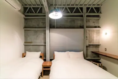 two beds in a room with white sheets at Rakuna Inn \u904a Kinshicho in Tokyo
