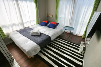 a bedroom with a bed with blue and red pillows at QU302 Edogawa Japanese Style has direct access to Akihabara and Shinjuku, with convenient free WiFi in Tokyo