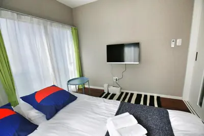 a bedroom with a bed and a tv on the wall at QU302 Edogawa Japanese Style has direct access to Akihabara and Shinjuku, with convenient free WiFi in Tokyo