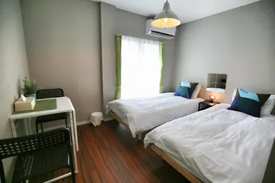 a room with two beds and a desk and a window at QU302 Edogawa Japanese Style has direct access to Akihabara and Shinjuku, with convenient free WiFi in Tokyo