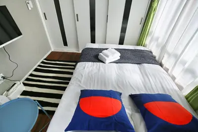a bedroom with a bed with red and blue pillows at QU302 Edogawa Japanese Style has direct access to Akihabara and Shinjuku, with convenient free WiFi in Tokyo