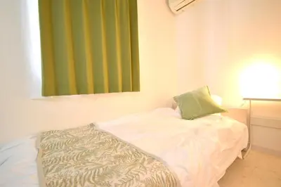 a bed in a room with a green window at Kamata332 \u84b2\u7530\u99c5\u306e2LDK\u30a2\u30d1\u30fc\u30c8\u30e1\u30f3\u30c8 \u7fbd\u75308min \u54c1\u5ddd8min in Tokyo