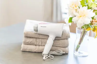 a hair dryer sitting on a table next to towels at Tokyo Urban Oasis- EYSI in Tokyo