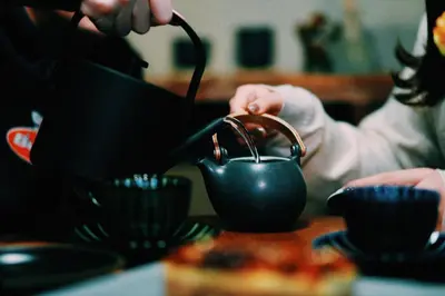 a person is pouring liquid into a tea pot at #11 -\u5e61\u30f6\u8c37 \u6cc9\u5eb5- \u53e4\u6c11\u5bb6\u306e\u5bbf in Tokyo