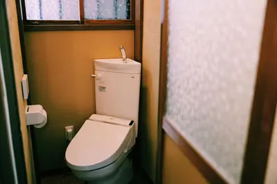 a small bathroom with a toilet and a window at #11 -\u5e61\u30f6\u8c37 \u6cc9\u5eb5- \u53e4\u6c11\u5bb6\u306e\u5bbf in Tokyo