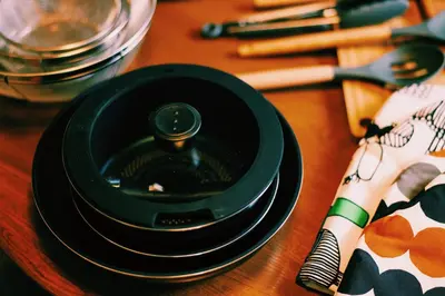 a stack of black plates on a wooden table at #11 -\u5e61\u30f6\u8c37 \u6cc9\u5eb5- \u53e4\u6c11\u5bb6\u306e\u5bbf in Tokyo