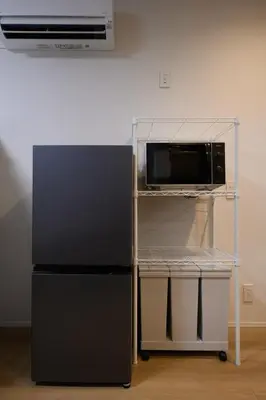 a microwave oven on a cart next to a refrigerator at TD Stay Tokyo in Tokyo