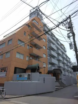 a tall brick building with a building at \u85e4\u548c\u30a8\u30af\u30b7\u30fc\u30eb\u9053\u7384\u5742d in Tokyo