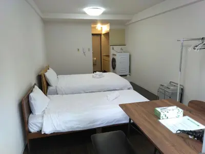 a hotel room with two beds and a table at \u85e4\u548c\u30a8\u30af\u30b7\u30fc\u30eb\u9053\u7384\u5742d in Tokyo