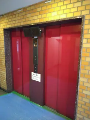 two red doors in a brick wall with a sign on it at \u85e4\u548c\u30a8\u30af\u30b7\u30fc\u30eb\u9053\u7384\u5742d in Tokyo