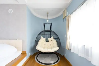 a black rattan chair in a room with a window at Hotel Iemirai Nakano Penthouse - SHINJUKU 12min train ride in Tokyo
