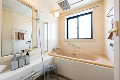 a bathroom with a tub and a sink and a window at Hotel Iemirai Nakano Penthouse - SHINJUKU 12min train ride in Tokyo