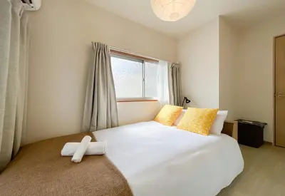 a bedroom with a large white bed with yellow pillows at New Super Deals Now Available Direct Access to Akihabara Shinjuku and Disneyland in Tokyo