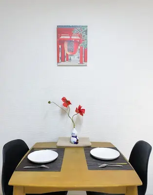 a wooden table with two plates and a vase with a flower at New Super Deals Now Available Direct Access to Akihabara Shinjuku and Disneyland in Tokyo