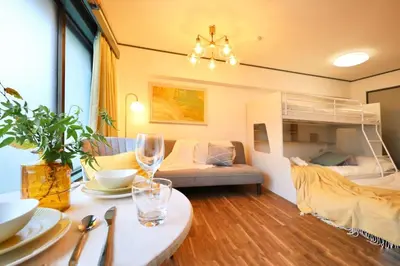 a living room with a table and a bunk bed at \u30b9\u30bf\u30fc\u30cf\u30a4\u30c4\u84b2\u7530 in Tokyo