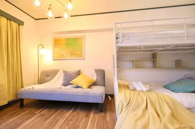 a bedroom with two bunk beds and a couch at \u30b9\u30bf\u30fc\u30cf\u30a4\u30c4\u84b2\u7530 in Tokyo