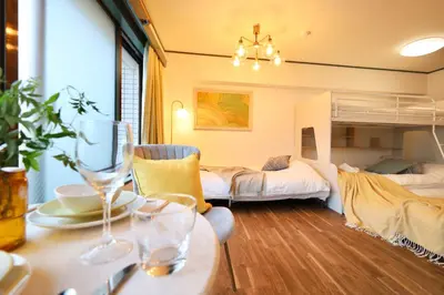 a living room with two beds and a table with glasses at \u30b9\u30bf\u30fc\u30cf\u30a4\u30c4\u84b2\u7530 in Tokyo