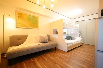 a bedroom with a bed and a couch in a room at \u30b9\u30bf\u30fc\u30cf\u30a4\u30c4\u84b2\u7530 in Tokyo