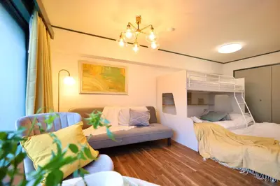 a room with a bunk bed and a couch at \u30b9\u30bf\u30fc\u30cf\u30a4\u30c4\u84b2\u7530 in Tokyo