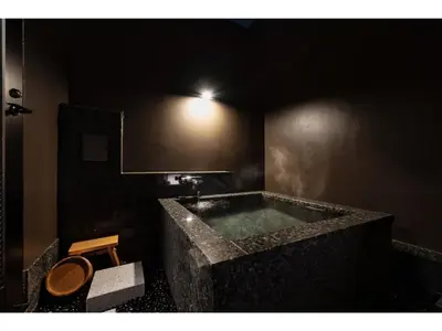 a bathroom with a large stone tub with a toilet at Prostyle Ryokan Tokyo Asakusa - Vacation STAY 48262v in Tokyo