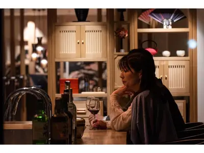 a woman sitting at a counter with a glass of wine at Prostyle Ryokan Tokyo Asakusa - Vacation STAY 48263v in Tokyo