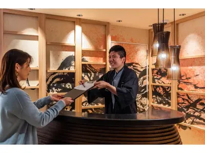 a woman standing in front of a bar talking to a man at Prostyle Ryokan Tokyo Asakusa - Vacation STAY 48267v in Tokyo