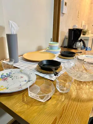 a wooden table with plates and glasses on it at Vista Ikegami 202 - Vacation STAY 17403 in Tokyo