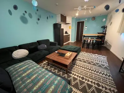 a living room with a couch and a table at Rakuna Inn \u52d5 Sasazuka in Tokyo