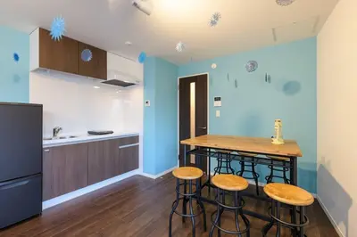 a kitchen with a counter and stools in a room at Rakuna Inn \u52d5 Sasazuka in Tokyo