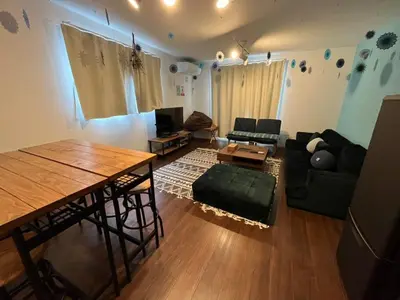 a living room with a table and a couch at Rakuna Inn \u52d5 Sasazuka in Tokyo
