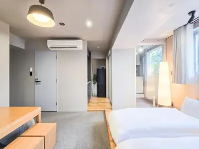 a bedroom with two beds and a desk at STAY ARI Shinjuku Takadanobaba Design awarded in Tokyo