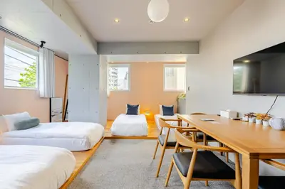a room with two beds and a dining table at STAY ARI Shinjuku Takadanobaba Design awarded in Tokyo