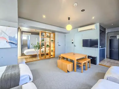 a living room with a table and a bedroom at STAY ARI Shinjuku Takadanobaba Design awarded in Tokyo