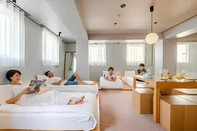 a group of people sitting on couches in a living room at STAY ARI Shinjuku Takadanobaba Design awarded in Tokyo