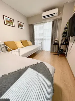 a living room with a bed and a couch at \u65b0\u5c0f\u5ca9\u30c7\u30e1\u30c6\u30eb303 in Tokyo