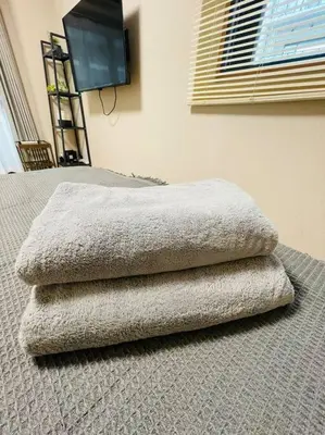 three towels sitting on a bed in a room at \u65b0\u5c0f\u5ca9\u30c7\u30e1\u30c6\u30eb303 in Tokyo
