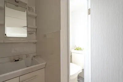 a white bathroom with a toilet and a sink at Asakusa Stay in Tokyo