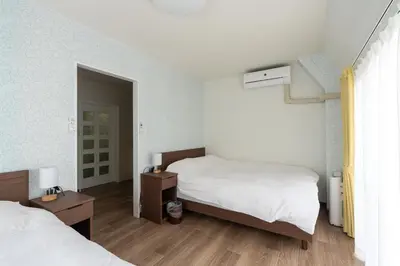 a bedroom with two beds and a mirror at Asakusa Stay in Tokyo