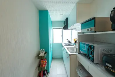 a small kitchen with blue cabinets and a sink at Asakusa Stay in Tokyo