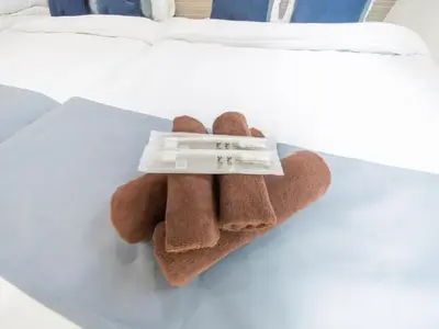 a teddy bear with a thermometer on a bed at BH Terace 102 - Vacation STAY 17368 in Tokyo