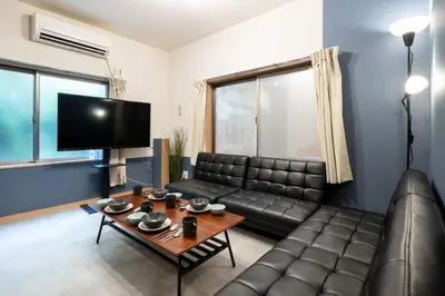 a living room with a leather couch and a table at A to - Vacation STAY 17369 in Tokyo