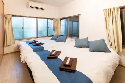 two beds in a room with large windows at A to - Vacation STAY 17369 in Tokyo