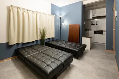 a living room with a leather couch and a kitchen at A to - Vacation STAY 17369 in Tokyo