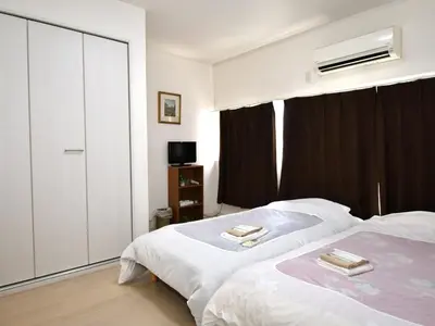 a bedroom with two beds and a dresser at Mizunokatachi Nishiarai -\u6c34\u306e\u304b\u305f\u3061 \u897f\u65b0\u4e95 - \u6d45\u8349\u3084\u4e0a\u91ce\u307e\u3067\u7d0420\u5206 \u7121\u6599Wi-Fi 2LDK\u3067\u5bb6\u65cf\u5c64\u306b\u304a\u3059\u3059\u3081 in Tokyo