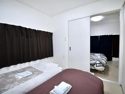 a bedroom with two beds and a mirror at Mizunokatachi Nishiarai -\u6c34\u306e\u304b\u305f\u3061 \u897f\u65b0\u4e95 - \u6d45\u8349\u3084\u4e0a\u91ce\u307e\u3067\u7d0420\u5206 \u7121\u6599Wi-Fi 2LDK\u3067\u5bb6\u65cf\u5c64\u306b\u304a\u3059\u3059\u3081 in Tokyo