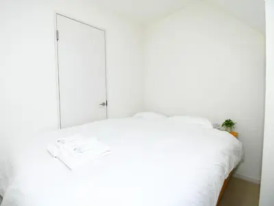 a bedroom with a white bed with a large mirror at Mizunokatachi Nishiarai -\u6c34\u306e\u304b\u305f\u3061 \u897f\u65b0\u4e95 - \u6d45\u8349\u3084\u4e0a\u91ce\u307e\u3067\u7d0420\u5206 \u7121\u6599Wi-Fi 2LDK\u3067\u5bb6\u65cf\u5c64\u306b\u304a\u3059\u3059\u3081 in Tokyo