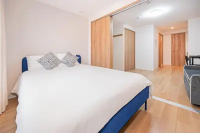a bedroom with a white bed and a sliding glass door at japan house T-Plaza sugamo in Tokyo