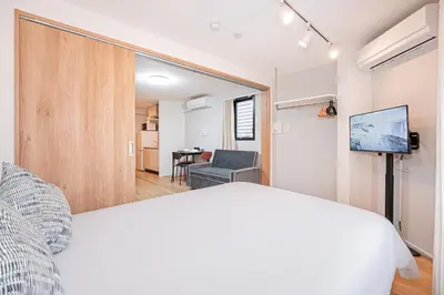 a bedroom with a bed and a living room at japan house T-Plaza sugamo in Tokyo